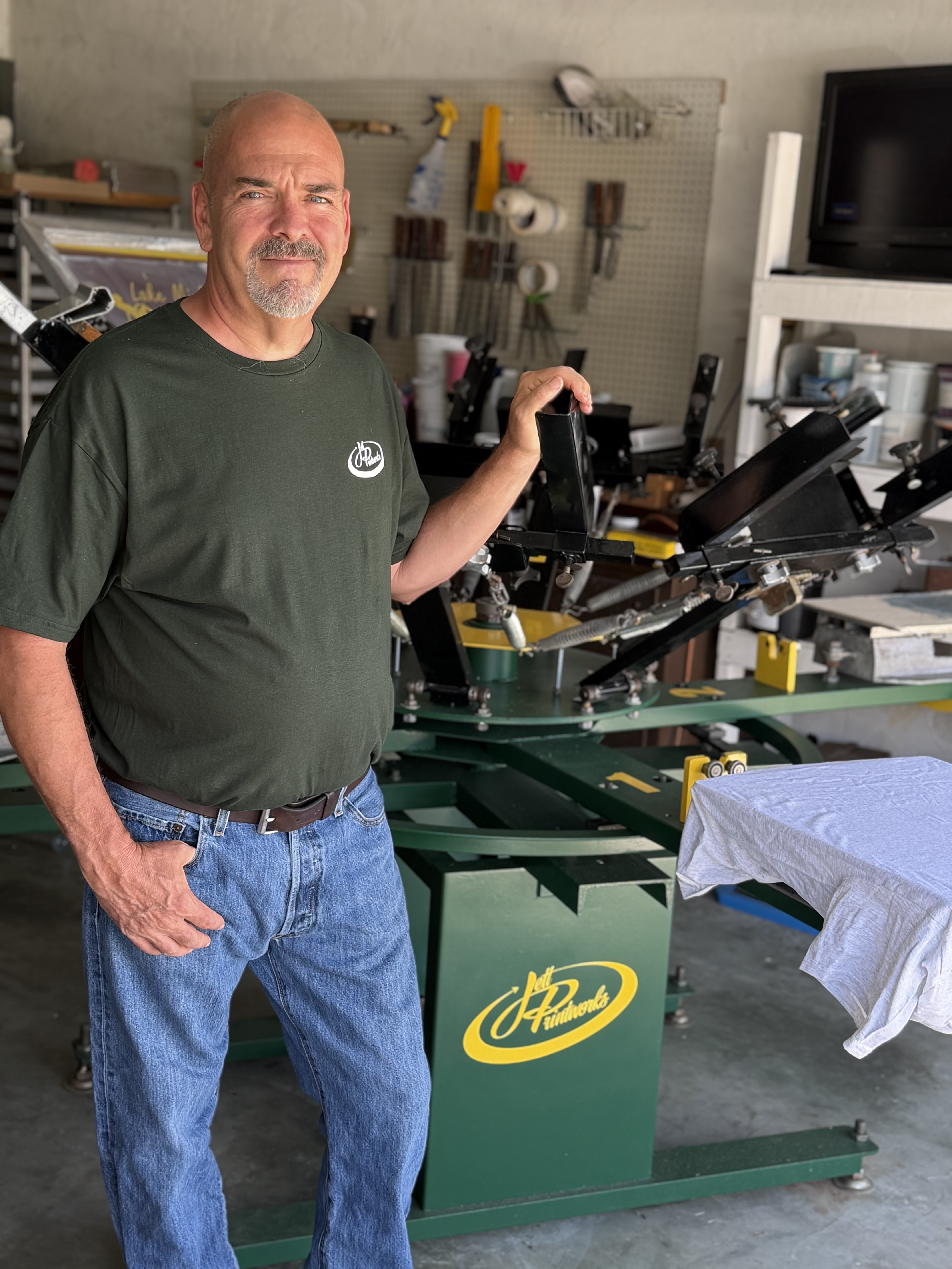 Matt Jett standing next to the original screenprinting press